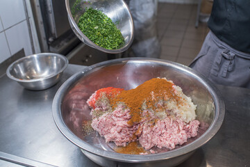 The chef mixes minced pork with different ingredients