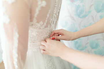 Wedding. The girl in a white dress and a guy in a suit sitting on a wooden chair, and are holding a beautiful bouquet of white, blue, pink flowers and greenery, decorated with silk ribbon