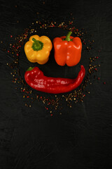 fresh and delicious, yellow, red and orange peppers on black background