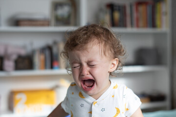 Little girl crying. One year old baby crying at home