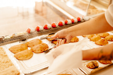 Bakery owner holding pastry wearing surgical mask. New normal concept.