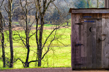 Wooden Outhouse with field and trees in background