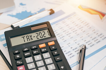 Tax word and 2021 number on a calculator. Business and tax concept. Pay tax in 2021 years. The new...