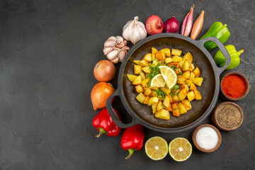top view tasty fried potatoes inside pan with different seasonings and vegetables on dark background cuisine meal food color pepper