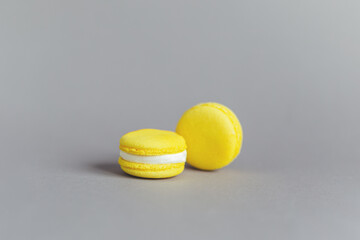 Tasty french yellow macaroons on a grey background.