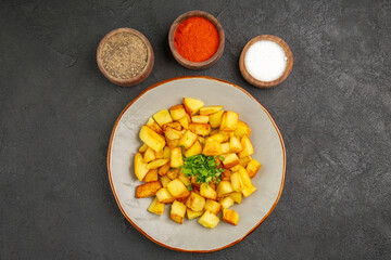 top view tasty fried potatoes inside plate with seasonings on dark floor photo food oil color dinner bread