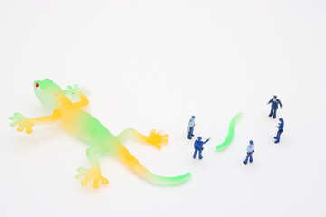 トカゲのしっぽ切りを囲む警察官のミニチュア 
