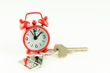 house key and red alarm clock, the concept of a home purchase