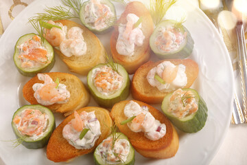Starter toast with salmon and shrimps in a creamy sauce with cucumber
