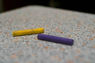 Pastel. Two pieces. Yellow and purple. On a light background. Crayons for drawing. Materials for artists.