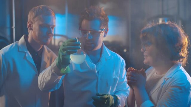 Team of crazy scientists doing experiment in large laboratory