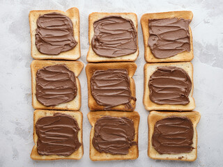 Top view lots of bread toast spread with chocolate-nut paste spread on table