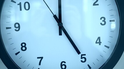 Black and white clock close up. Five clock on the dial