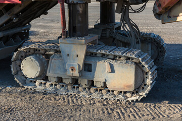 Excavator tracks. Old iron caterpillars of the bulldozer of the tractor on the road. bulldozer caterpillar tracks. Black caterpillar tractor grader with the wheels on the ground.