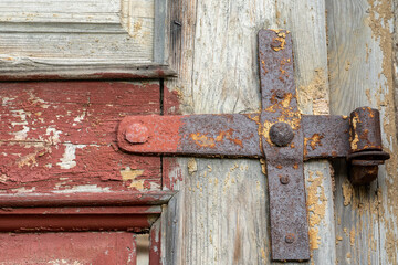 rusty door hinges close-up on an old wooden door.  Forged metal products made in the last century.