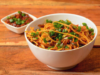 Veg Noodles a popular indo-chinese dish made with noodles and vegetables, served over a rustic wooden background, selective focus