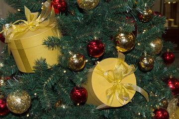 Close-up of a Christmas tree decorated with bright gift boxes and balloons. Christmas decor