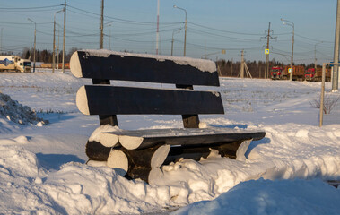 Winter roadside black bench. Snow-covered blask bench © Sofya