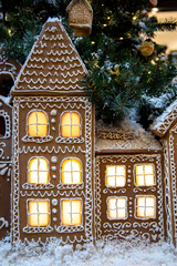Gingerbread house in the living room under the tree. Christmas evening. Great holiday mood