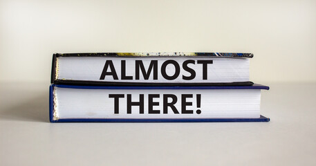 Almost there symbol. Books with words 'almost there' on beautiful white table. White background....