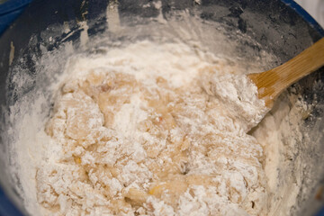Bakery products. Christmas cookies. Dough. Flour. Wooden spoon kneads the dough.