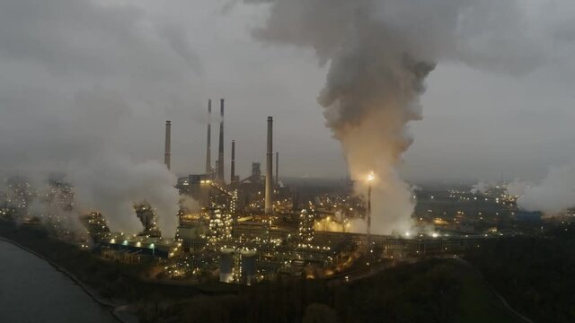 Aerial crane shot, smoke, flames and steam from industrial coking plant factory