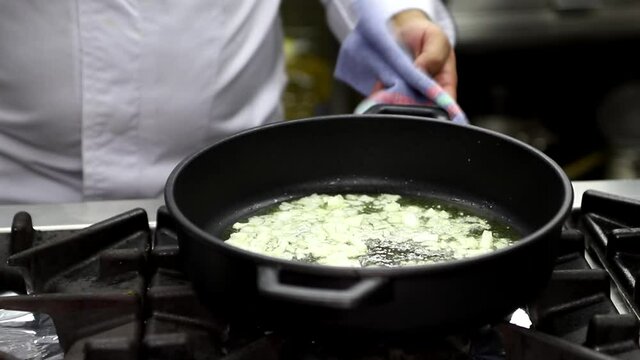 Cocinero haciendo un sofrito de cebolla