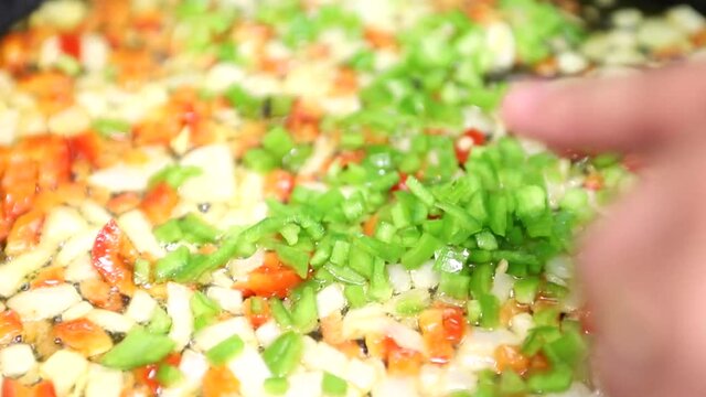 Cocinero haciendo un sofrito de cebolla y pimiento
