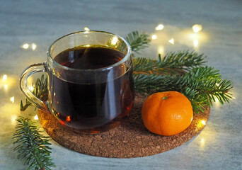 a cup of hot tea with needles and tangerine