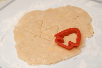 Bakery products. Christmas cookies. Cookie cutters. Cutting Christmas cookies from the dough. Dough on a cutting board. Cooking. Flour. Rolling pin. Christmas mood.