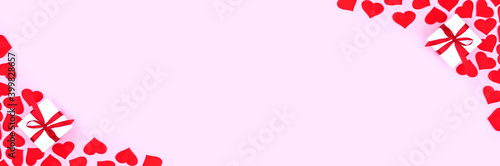 Background with gift and hearts with free space for text on pastel pink background, wide angle view. Flat lay, top view. Valentines day concept. Mother's Day concept. Banner.