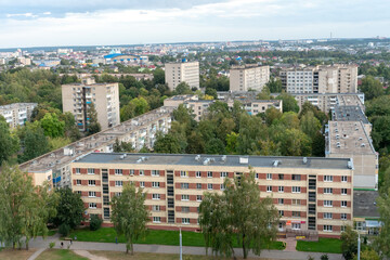 top view of the residential area of a small city. View of the houses of a residential complex in a green area next to trees. A city with a large number of green spaces.