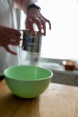 Mesh flour sifter working in cook s hand. Background with free copy text space. Preparation of dough for dumplings.