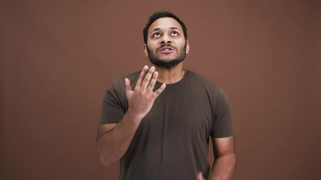 Its enough for me. Irritated indian man showing fed up gesture, feeling bored and tired, brown background