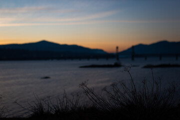 Beautiful sunset landscape with river, mountains and bridge