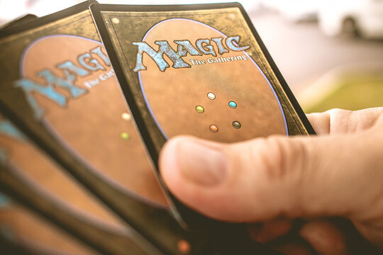 Magic: The Gathering. Homem segurando cartas do jogo de estratégia Magic: The Gathering.