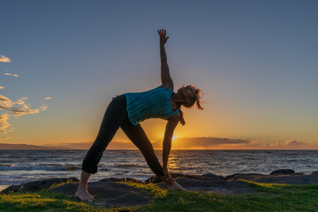 Woman Practicing Yoga at Sunset on a Maui Beach
