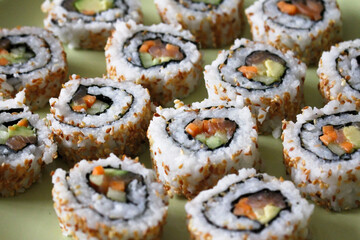 Fresh delicious Japanese sushi with avocado, cucumber and salmon
