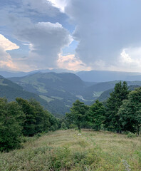 Beautiful view of the peaks of Monte Baldo. Stunning cloudy and panoramic view. Green Pastures in Italian Alps