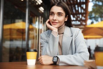 Young woman talking to someone, sitting with friend in coffee shop. Businesswoman having a meeting in cafe, looking at person