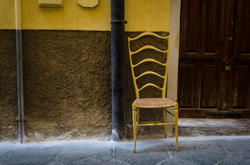 Sedia gialla fuori dalla porta di una casa nel centro storico di Cagliari