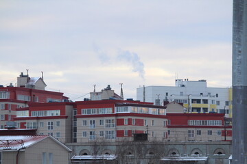 Roofs of modern multi-storey panel houses against the background of a light cloudy winter sky
