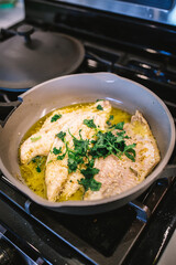 Fish Cooking in Ceramic Pan with Olive Oil