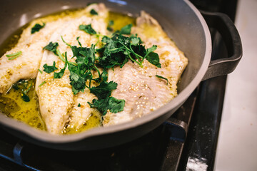 Fish Cooking in Ceramic Pan with Olive Oil