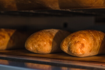 Ciabatta bread in an industrial oven. Making craft bread at the bakery