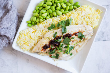 Fresh Fish Plated on Saffron Rice Dish and Shelled Edamame