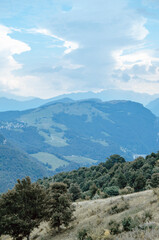 Beautiful view of the peaks of Monte Baldo. Stunning cloudy and panoramic view. Green Pastures in Italian Alps