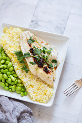 Fresh Fish Plated on Saffron Rice Dish and Shelled Edamame