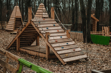 Wooden ladder obstacle with rope for children on a playground