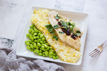 Fresh Fish Plated on Saffron Rice Dish and Shelled Edamame